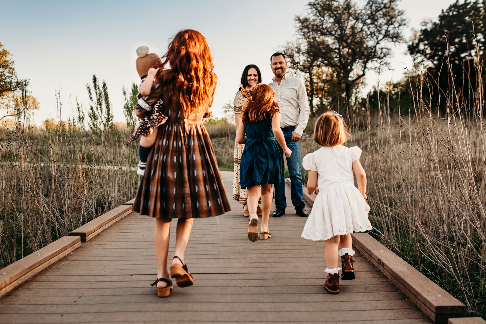 A family walking together along a boardwalk at golden hour