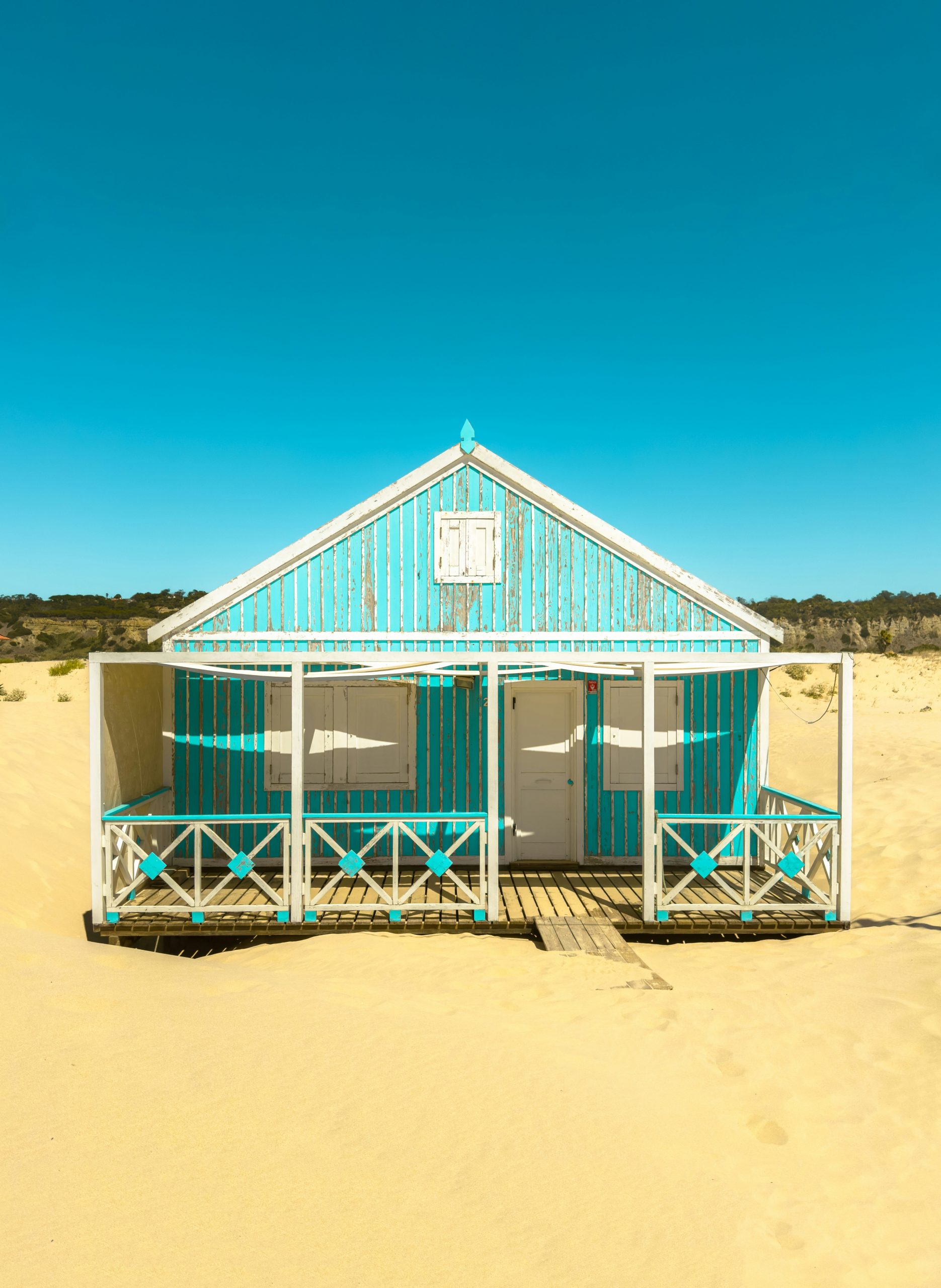 A weathered, colourful wooden beach cottage on the dunes south of Lisbon